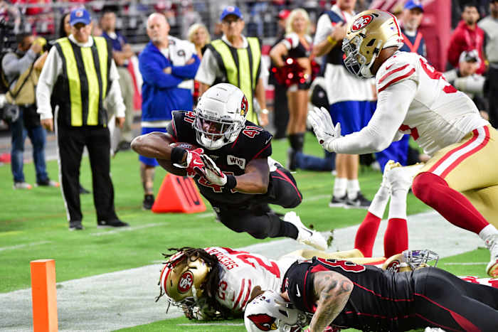 Cardinals running back Kenyan Drake dives over 49ers cornerback Richard Sherman to score a touchdown in a 2019 game at State Farm Stadium.